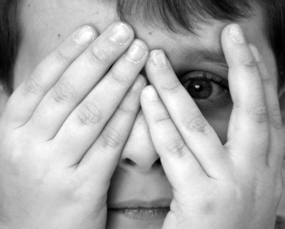 child hands over eyes